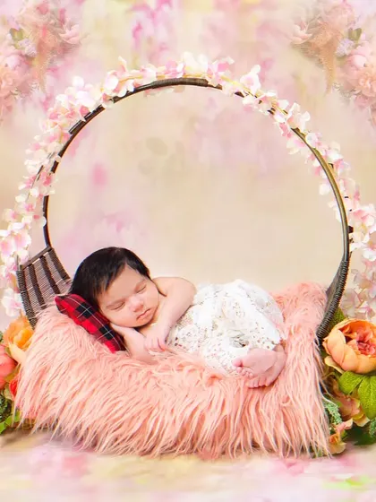 A newborn sleeps peacefully on a soft fur blanket inside a circular prop. The simple elegance of this setup keeps the focus on the baby.