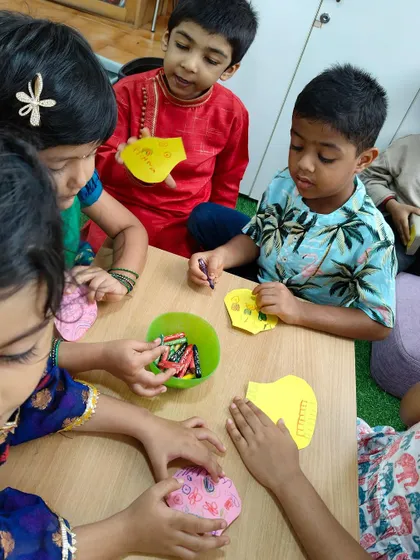 Children collaborating on a craft project for Janmashtami. They learn to share materials and ideas, developing social skills alongside their creativity.