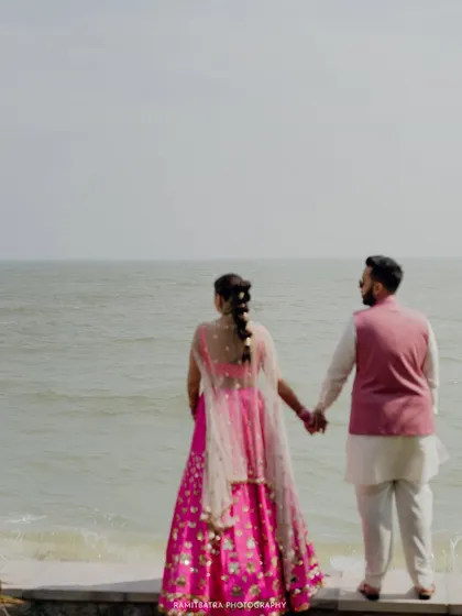 The couple holds hands and looks out at the sea, a quiet moment of reflection during their Thailand wedding.