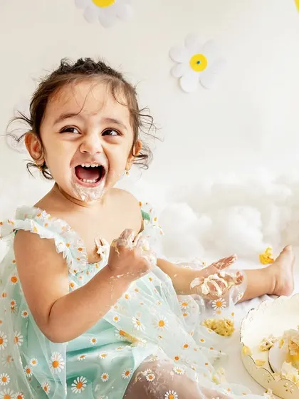 This is the pure, unfiltered joy of a first birthday! This little pataka had the best time with her daisy-themed cake smash. My goal is to capture your child's personality, and this picture of her laughing with a face full of cake says it all.