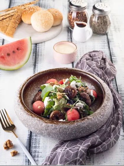 This salad is shot with bright, natural-style lighting to emphasize its freshness and healthiness. The white wooden background adds to the clean, wholesome feel of the dish.