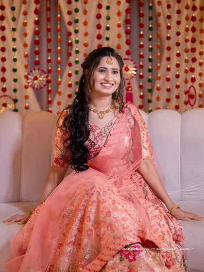 The bride looking radiant during her Mehendi ceremony. Her floral-patterned lehenga and happy smile perfectly capture the festive mood.