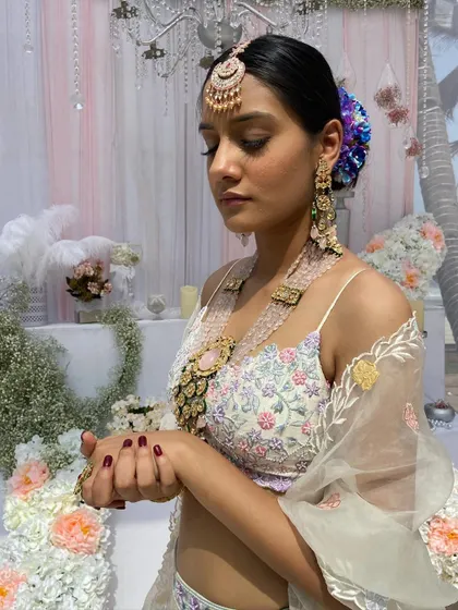 A serene portrait of the bride at her Mehendi, her hair adorned with beautiful blue and purple flowers.