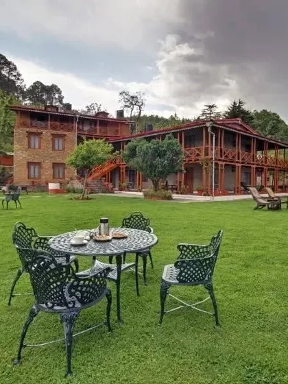 A view of the Eco Lodge from its large lawn, showing the multi-level wooden balconies that provide guests with private outdoor space.