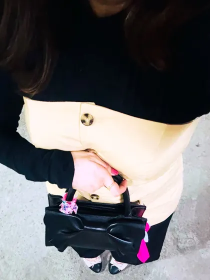 A top-down view of the layered outfit, focusing on the button details and accessories.