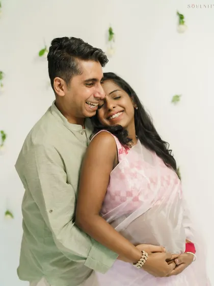 Laughter and love fill the frame in this sweet indoor portrait. The soft pink of her saree adds a delicate, traditional touch.