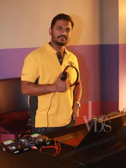 DJ Raghu in his element, holding his headphones and focused on the mix. He's one of our amazing resident DJs who knows exactly how to keep the dance floor packed and the energy high.