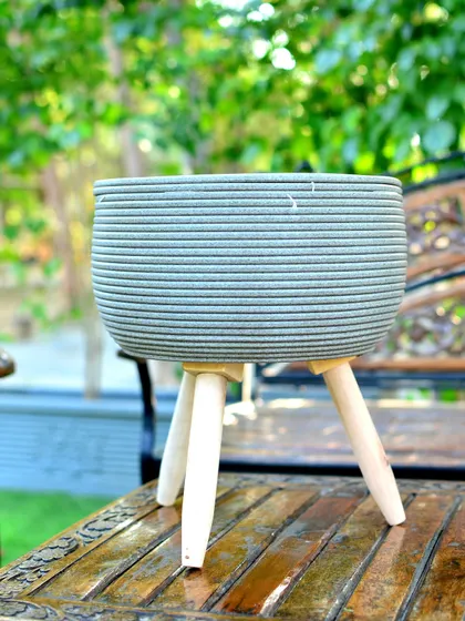A minimalist grey-green planter on tripod legs, waiting for the perfect plant to complete its look.
