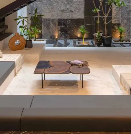 A close-up of the sunken lounge, detailing the custom live-edge wood coffee table and the integrated planters. Every detail is chosen to contribute to the overall feeling of tranquility and craftsmanship.