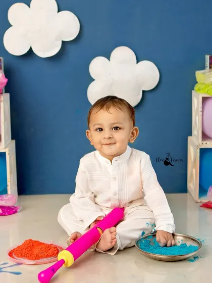 This little one is exploring all the fun props, including the colorful powders and pichkari.