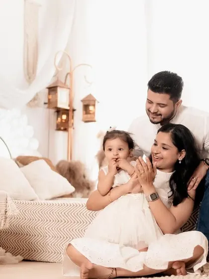 A happy family enjoying their time together in the studio. The little girl's shy smile is absolutely precious in this light-filled, candid photo.