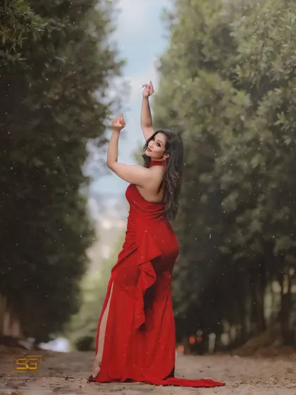 A dramatic pose in the red gown, showing its full silhouette.