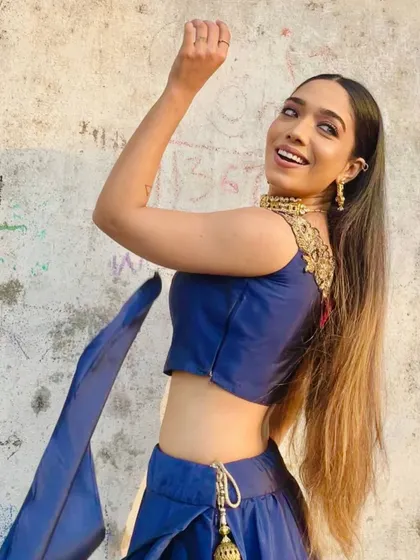 "Elegance is a beauty that never fades." A candid shot in a royal blue traditional outfit, capturing a moment of grace and happiness.