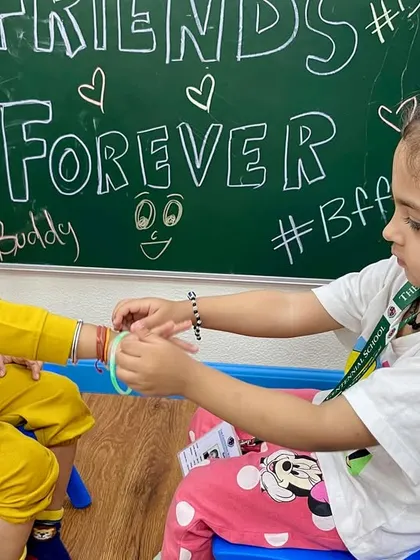 Two friends exchange friendship bands. Our Friendship Day activities are designed to promote social-emotional learning and create lasting bonds.
