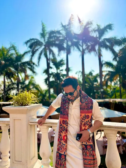 A stylish pose against a sunlit backdrop of palm trees, showcasing a relaxed yet chic ethnic look.