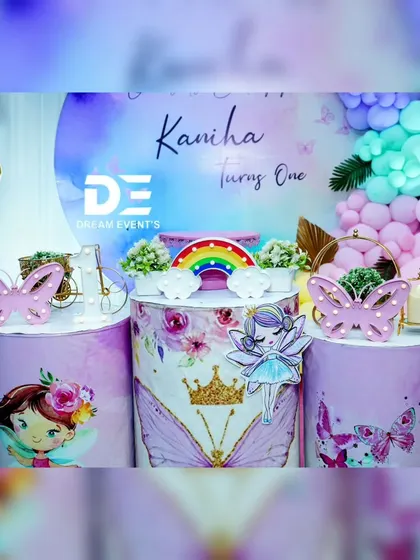 A close-up of the cake table pedestals from Kaniha's butterfly party. The design features fairy and butterfly graphics, a light-up rainbow, and a mini crown.