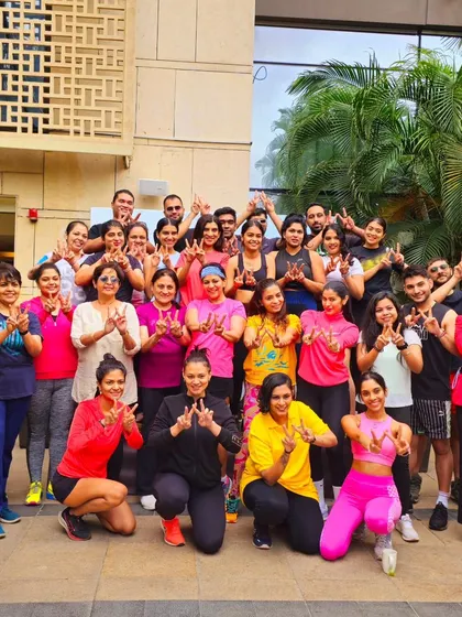 Another fantastic group shot showing the positive energy and success of a corporate wellness event. The "W" for wellness sign is a great touch.