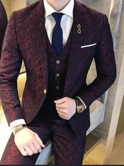 A customer looking sharp in a patterned maroon three-piece suit. The fit is perfect, showing the quality of our ready-to-wear collection.