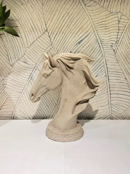 An elegant horse head bust with a smooth, stone-like finish. This classic and timeless sculpture is perfect for adding a touch of grace to a study or living room.