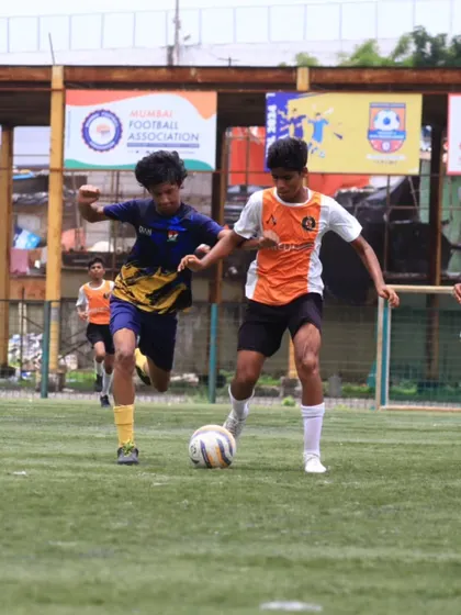 A TFA player shields the ball from an opponent during the MFA 1st Division match.