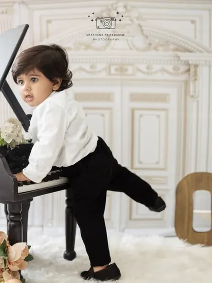 A playful shot of a one-year-old boy trying to play the piano. Our milestone sessions are all about capturing the curious and fun-loving nature of toddlers.