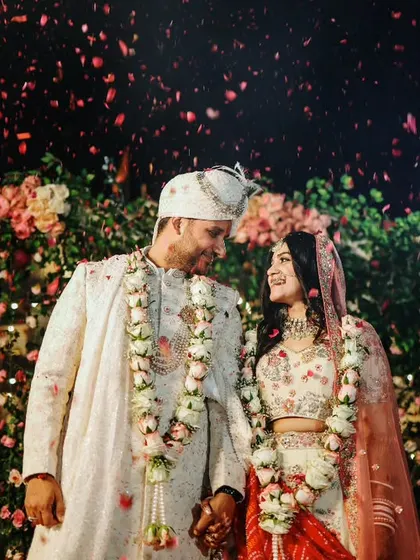 An intimate night-time shot of the couple after their ceremony, surrounded by a canopy of flowers and lights.