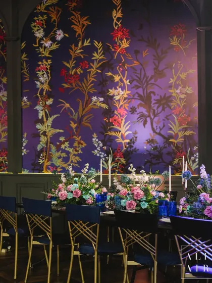 A dining setup at 'Midnight Mirage', with custom floral wallpaper creating a dramatic and elegant backdrop. The design was all about immersing guests in a world of natural grace and mystical charm.