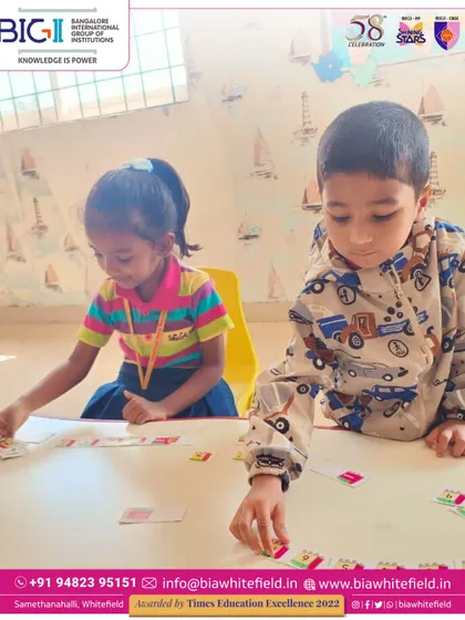 Two preschoolers work together on a number matching game. Collaborative activities like this teach teamwork alongside academic concepts.