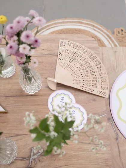 A close-up of the custom-designed coasters and hand fans, small details that enhance the guest experience.