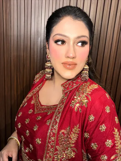 A close-up of the client's face, her glam makeup perfectly balanced by the traditional earrings.