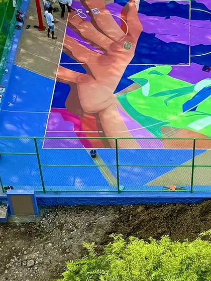 This section of the NBA 2K mural shows a hand reaching for the ball, symbolizing the aspiration and passion of the players. The vibrant colour palette was chosen to evoke energy and movement.