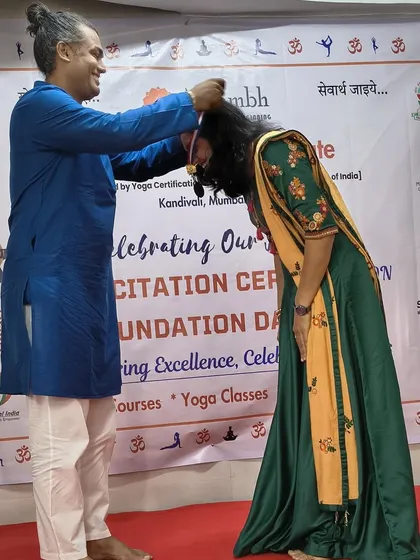 A touching moment as an instructor places a medal on a graduating student, honoring her achievement with respect and blessings.