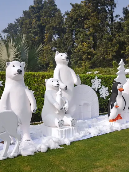 A herd of winter animals, including polar bears, penguins, and reindeer, creates an impressive and immersive scene on the lawn.