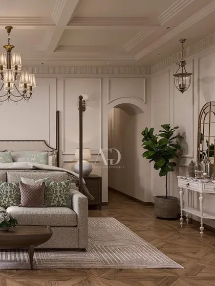 A cozy corner in a classic bedroom, featuring a comfortable sofa and distressed-finish console table. The herringbone wood floor and paneled walls provide a beautiful, textural backdrop.