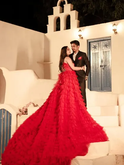 A Santorini-themed pre-wedding shoot looks even more stunning with our vibrant red ruffle gown.