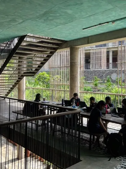 Students study in an open-air breakout space, with views of the surrounding green campus. These spaces are designed to be comfortable and inspiring, using the landscape as a natural backdrop for learning.