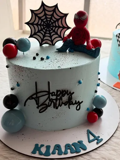 A cool and modern Spider-Man cake. I kept the design simple with a light blue frosting, a Spidey topper, and coordinating balloon-like spheres.