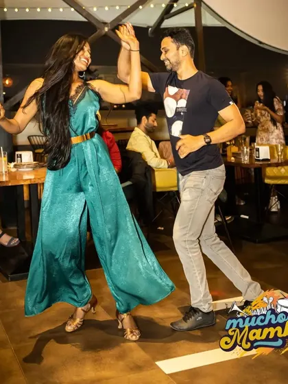 A high-five mid-dance captures the fun and informal spirit of our socials. It's all about connection and having a great time.
