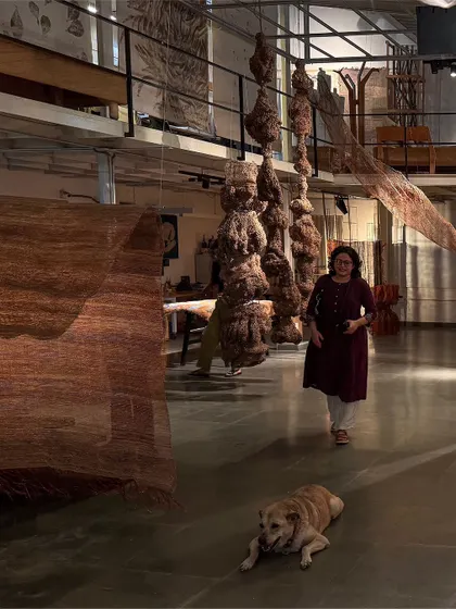 A visitor interacts with the hanging fiber sculptures from our 'Cu+Fibers' exhibition. Each piece is a result of improvisation and response to the materials, creating an aggregate of joys and visible ideas shaped by light and form.