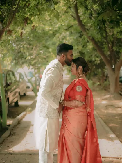 A tender moment with the groom kissing the bride's forehead, a timeless expression of love and care.