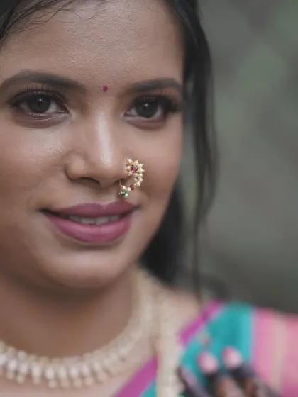 A detailed close-up of the bride's face. The focus is on clean, defined features, including the eyes, lips, and the traditional 'naath'.