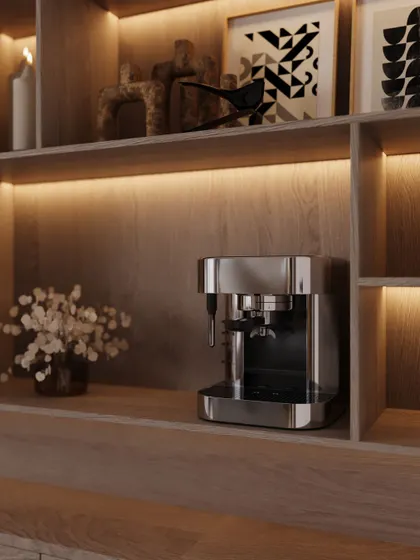 Every modern home office needs a great coffee station. We integrated this sleek espresso machine into a custom wooden niche with warm, under-shelf lighting. The shelves above are styled with art and decor, making even a utility corner feel curated and beautiful.