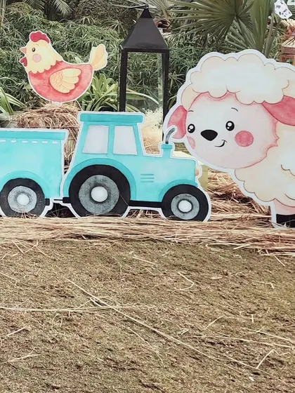 A cute cutout of a sheep next to a blue tractor. These props were scattered around the party area to make the entire space feel like a fun and friendly farm.