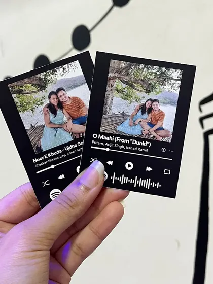 Two versions of a Spotify card for the same photo, each linked to a different favorite song.