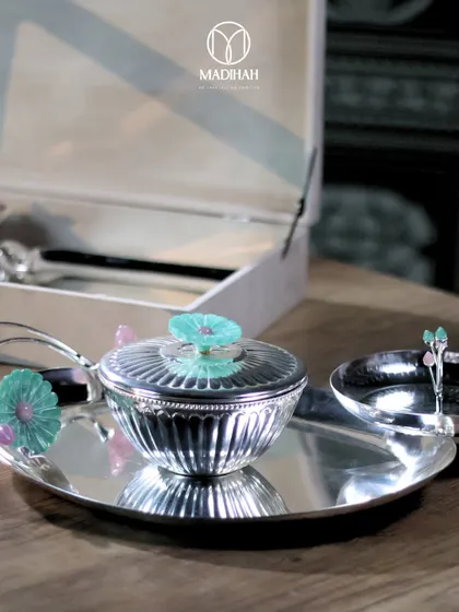 A detailed shot of the silver-plated lidded bowl and nut bowl from the Daisy Collection. The fluted silver and the hand-painted enamel flower on the lid showcase the fine craftsmanship.
