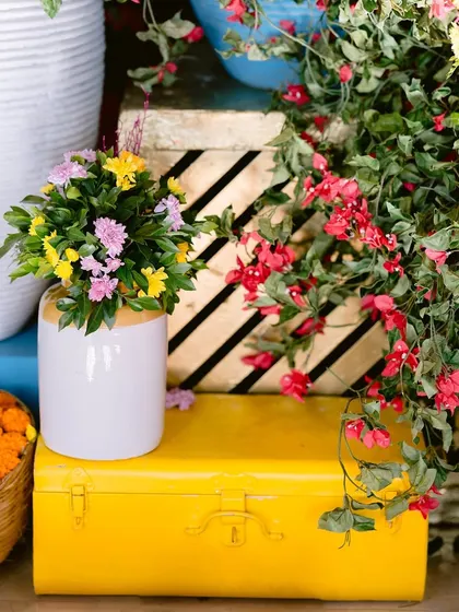 A close-up of the vibrant floral decor and a quirky yellow trunk used as a prop for the Mamera ceremony.