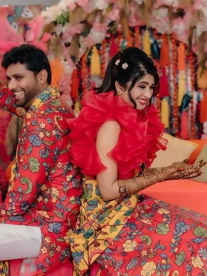 Fun and candid moments from a vibrant Mehendi event. The couple is sharing a laugh, surrounded by the bright, festive atmosphere I designed for their special day.