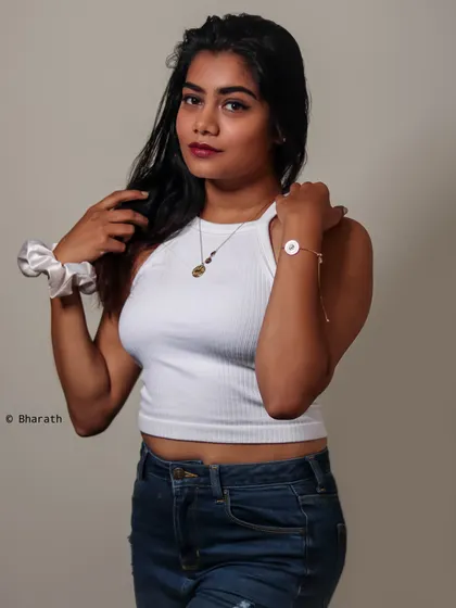 This studio portrait uses a simple setup, a white top and jeans, to create a photo that feels authentic and approachable.