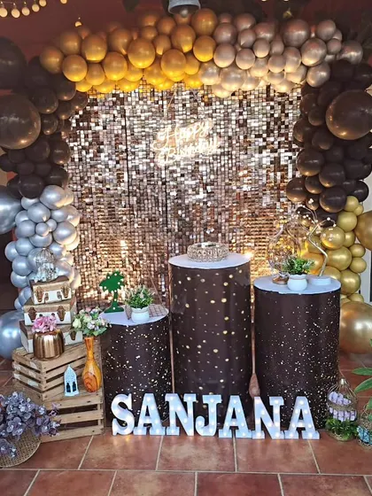 A simple and chic birthday decoration for Sanjana's bash. The gold sequin backdrop, brown and gold balloon garland, and light-up letters create a warm and glamorous atmosphere.