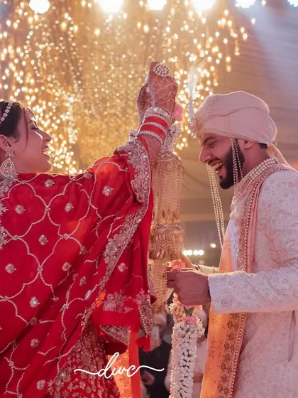 A moment of pure triumph and joy during the Jaimala, as the bride successfully places the garland on the groom under a shower of lights.